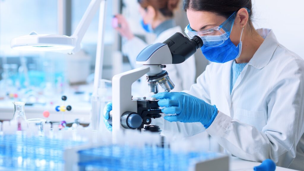 Young,Researcher,Looking,At,The,Samples,Under,The,Microscope,,She