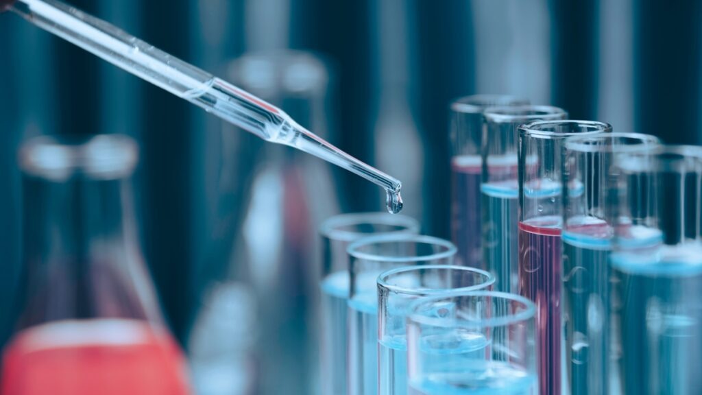 Researcher,With,Glass,Laboratory,Chemical,Test,Tubes,With,Liquid,For