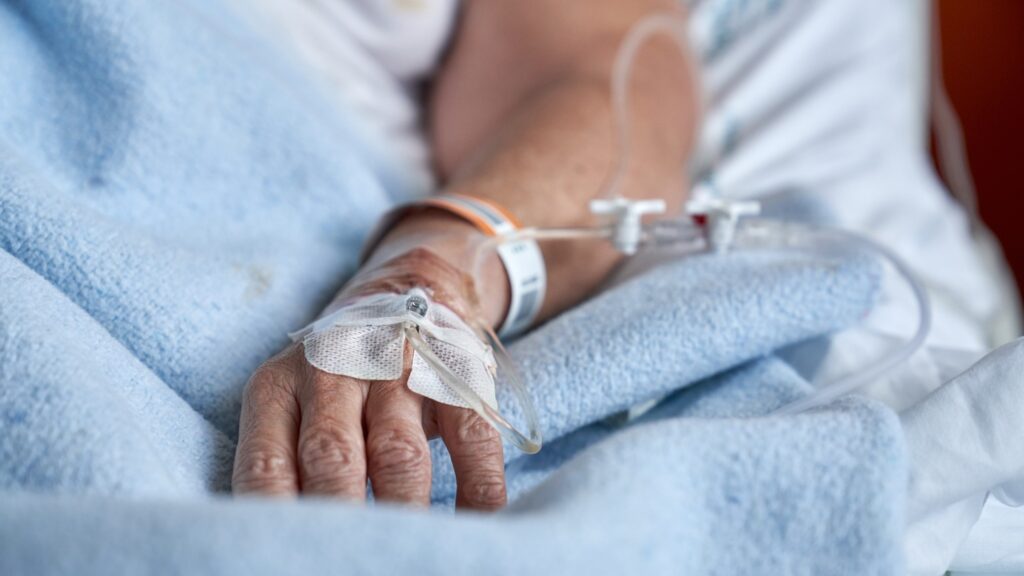 Hand,Of,Crop,Anonymous,Patient,With,Attached,Catheter,For,Intravenous